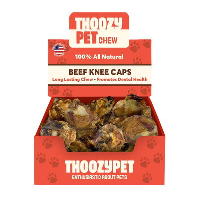 A ThoozyPet box labeled USA-Sourced Beef Knee Cap Bone Dog Chews 25ct shows several 100% all natural, long-lasting dog chews that promote dental health. Paw prints decorate the box.