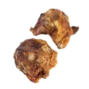 Two pieces of cooked or dried, brownish meat with a textured surface, isolated on white—ideal as ThoozyPet USA-Sourced Beef Knee Cap Bone Dog Chews 25ct for natural dog treats.