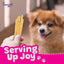 A hand holds Woof Island Coconut Sticks—rawhide-free, all-natural dog chews—with a happy, fluffy brown dog in the background. Bold pink and white text reads “Serving Up Joy,” with paw prints and the Woof Island logo above.