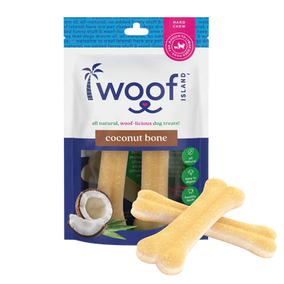 A package of Woof Island Natural Rawhide Free Coconut Dog Bones Healthy Chews 2 pcs is shown with two bone-shaped chews in front and coconut imagery on the packaging. The bag highlights all natural, hard chew, and health benefit icons.