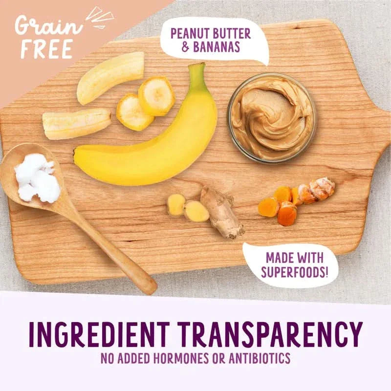 Health Extension peanut butter banana dog treats with natural ingredients including bananas and coconut on a wooden board
