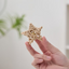 Hand holding a star-shaped wicker rattan cat toy, perfect for engaging feline playtime