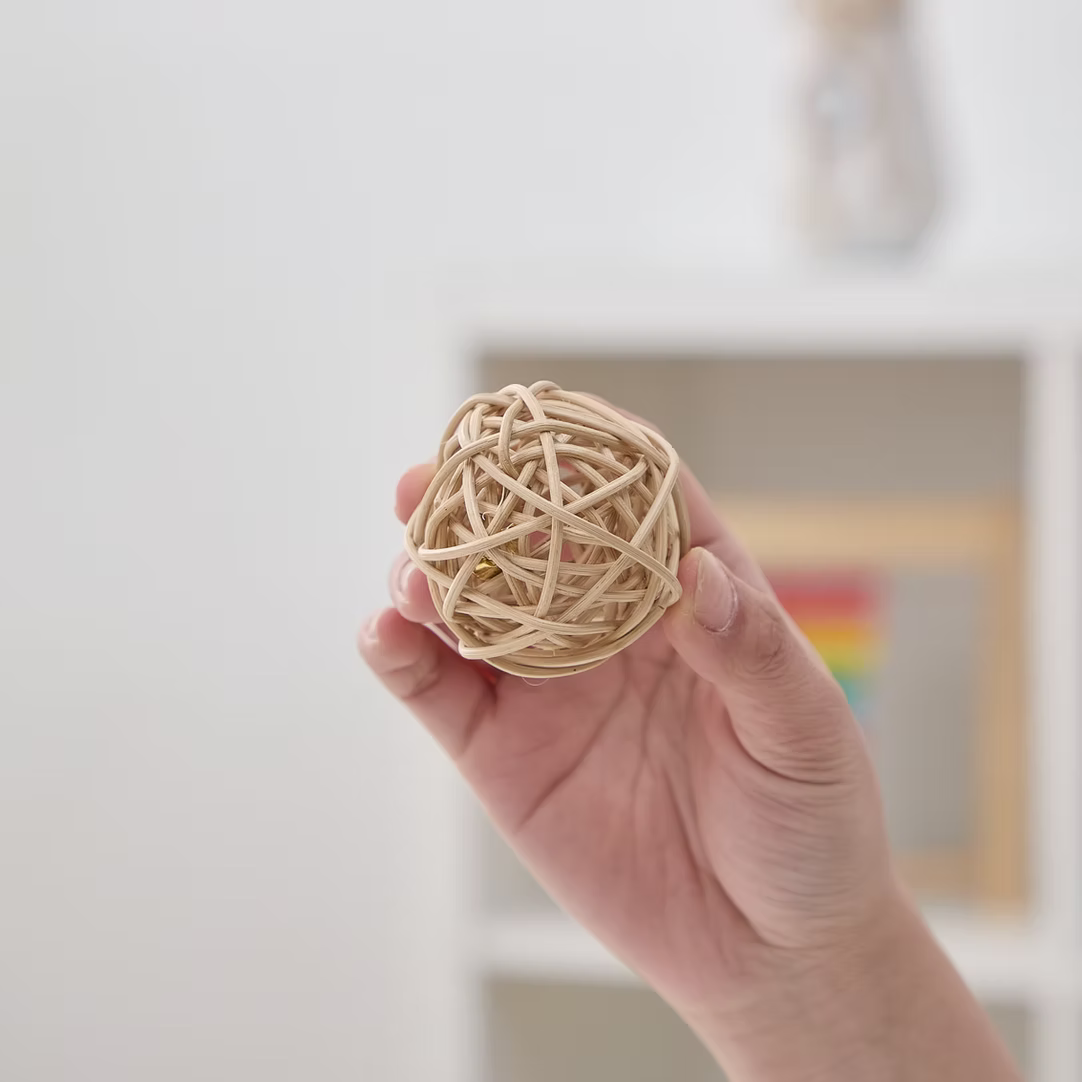 PetPals wicker rattan cat toys hand holding a natural woven ball for playful feline entertainment