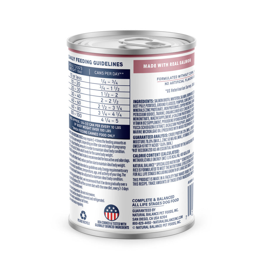 A can of Natural Balance Specialized Nutrition Sensitive Skin & Stomach Formula Adult Salmon & Brown Rice Wet Dog Food features a white label with blue and red accents, displaying feeding guidelines, ingredients, Omega Fatty Acids, and product claims.
