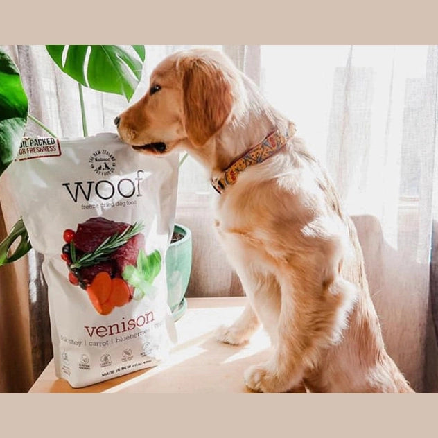 A golden retriever with a bag of freeze dried venison dog food by The New Zealand Natural Pet Food Co