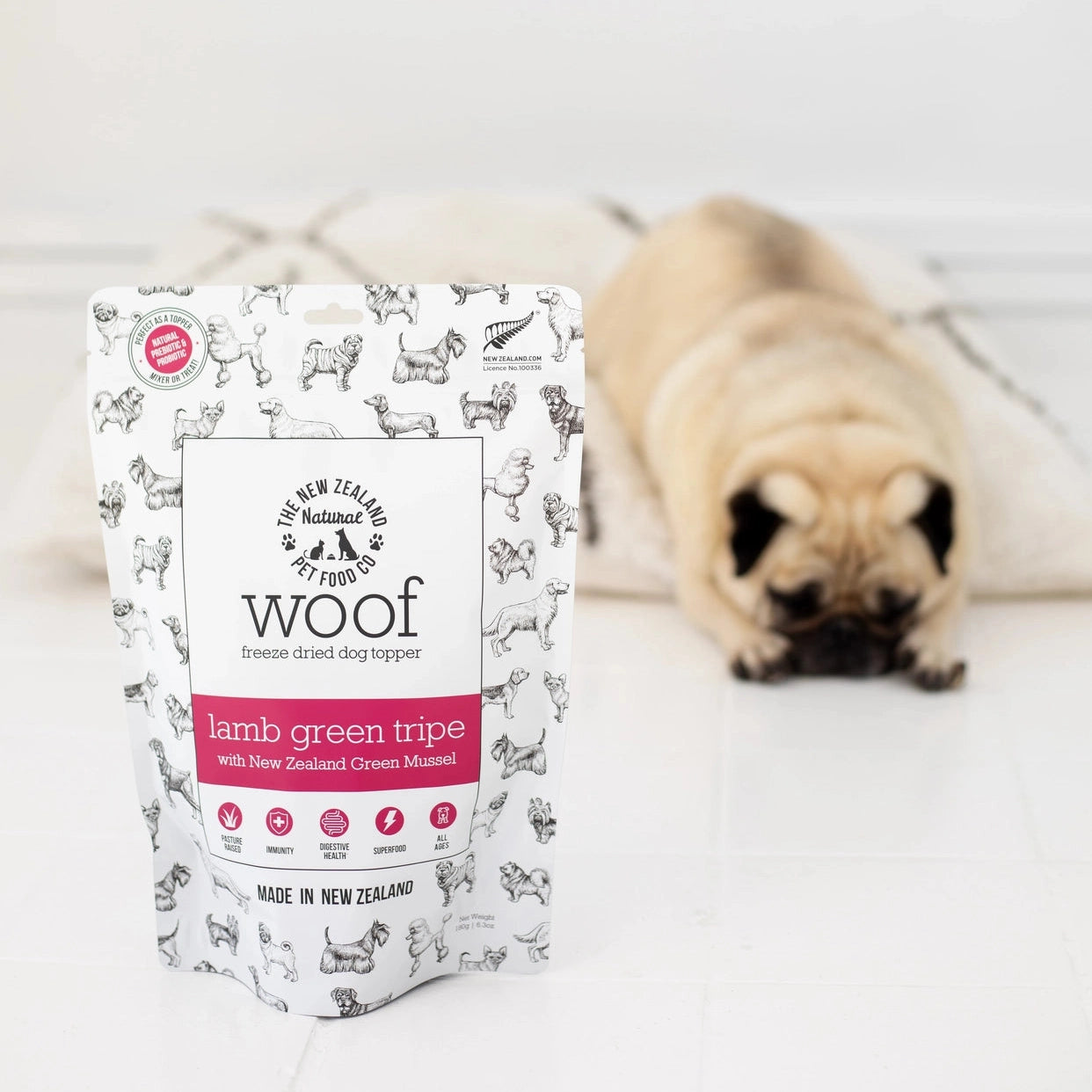 Woof Lamb Green Tripe Dog Food Topper from The New Zealand Natural Pet Food Co with a pug in the background