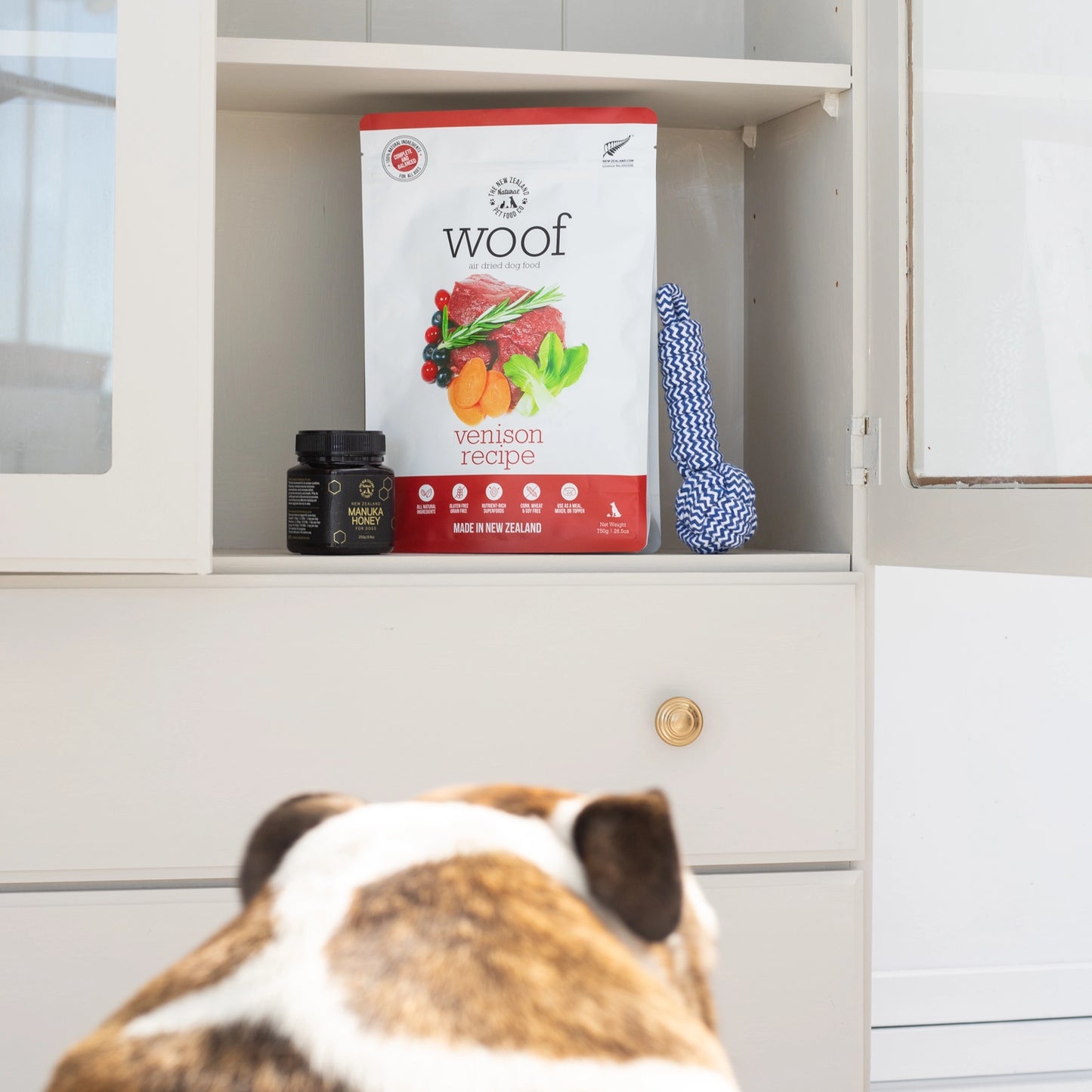The New Zealand Natural Pet Food Co venison air dried dog food on shelf with dog looking at it